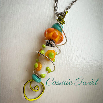 Colorful beaded spiral pendant necklace on a silver chain; orange, teal, lime-green beads with a yellow spiral, titled 'Cosmic Swirl'.
