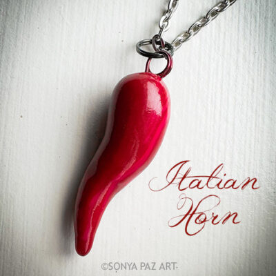 Red Italian horn pendant on a silver chain, against a light background; text reads 'Italian Horn'.