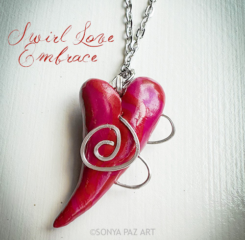 Pink horn-shaped pendant with silver spirals on a chain against a white background (art necklace).